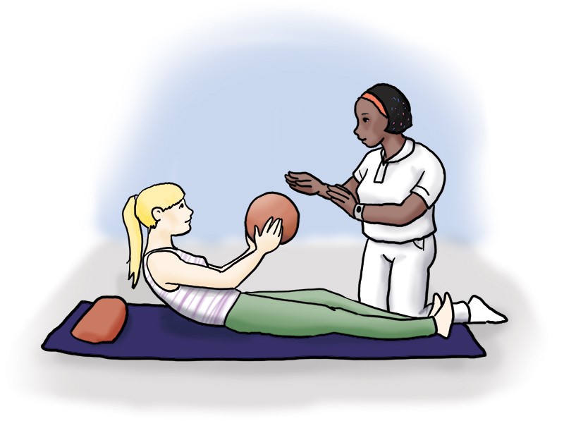 Patientin liegt auf einer Sportmatte und wirft mit leicht aufgerichtetem Oberkörper einen Ball in Richtung ihrer Physiotherapeutin, die neben ihr kniet und die Arme zum Fangen bereithält.